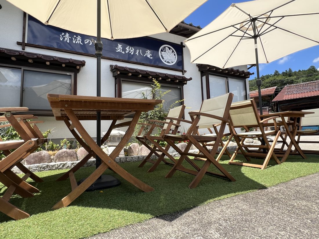店先のテラス席。パラソルと木のテーブル